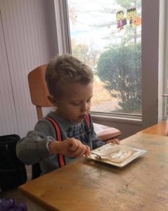 Feeding Skill Practice Boy learning intrinsic motivation by trying fun, educational OT Therapies on his own.
