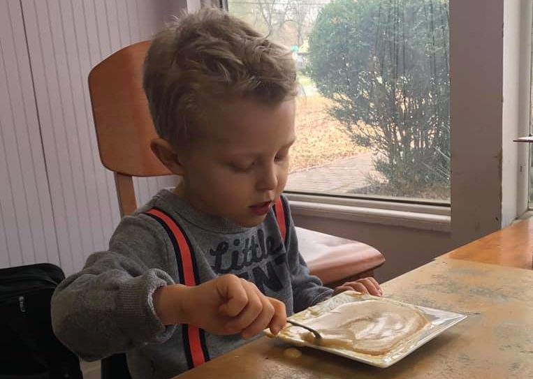 Feeding Skill Practice Boy learning intrinsic motivation by trying fun, educational OT Therapies on his own.